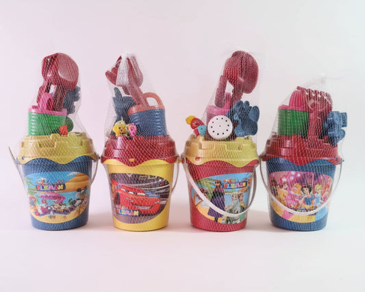 Four colorful sand buckets with toys inside on a wooden surface.