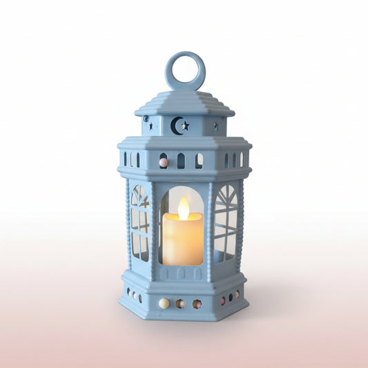 Light blue lantern with a lit candle inside on a wooden surface.