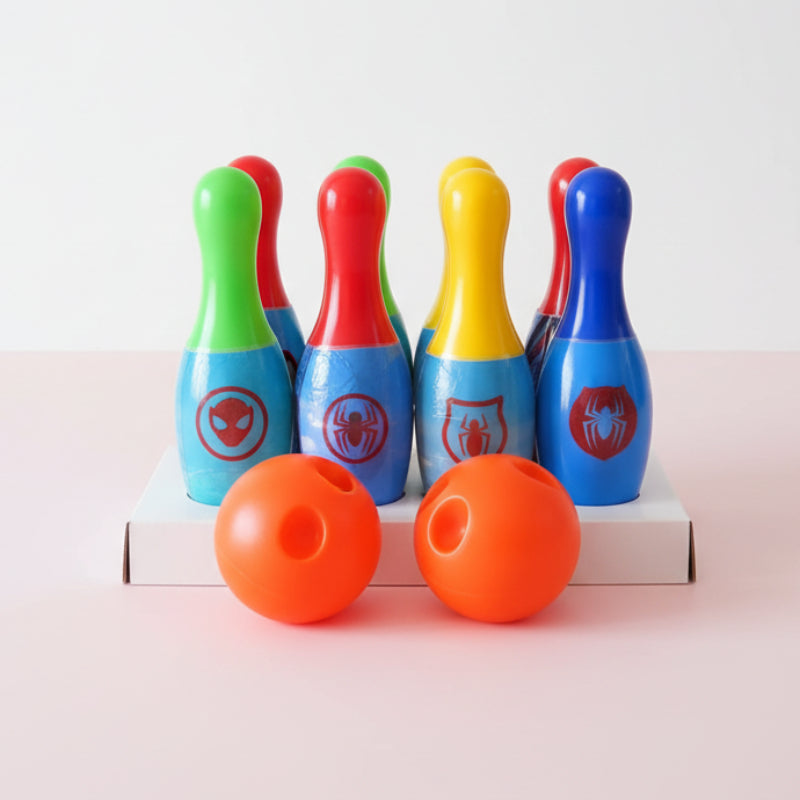 Colorful toy bowling pins with two orange balls on a wooden surface.