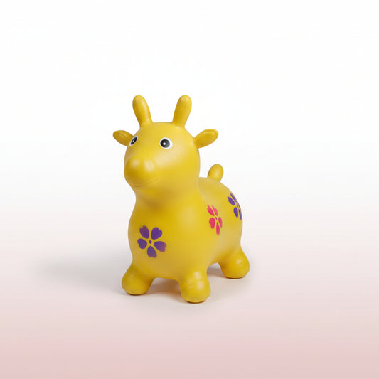 Yellow toy giraffe with a purple flower on a cardboard box surrounded by other toys.