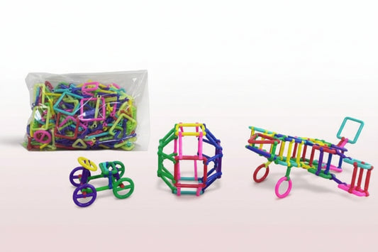 Colorful magnetic building toys on a wooden surface with a clear bag of additional toys in the background.