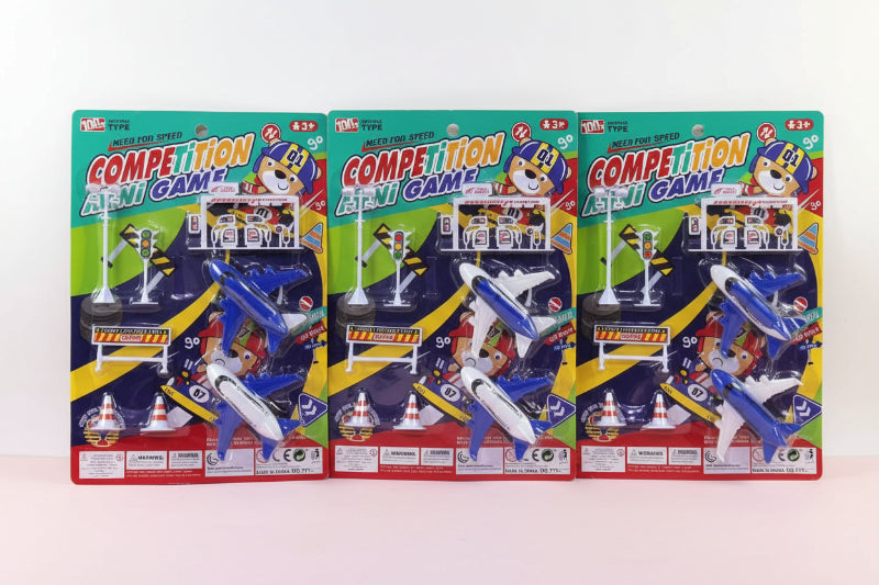 Three packages of a 'Competition Pen & Gam' toy set on a wooden surface.