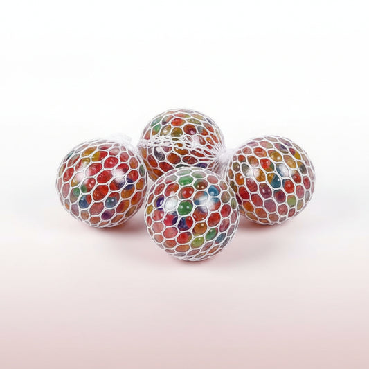 Colorful gelatinous balls in a drawstring bag held by a hand on a light gray background