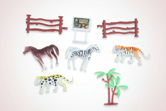 Toy animals and fences on a wooden surface