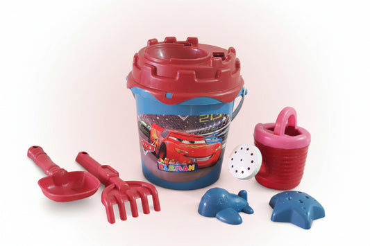Children's sand toys including a bucket, spades, and molds on a wooden surface.