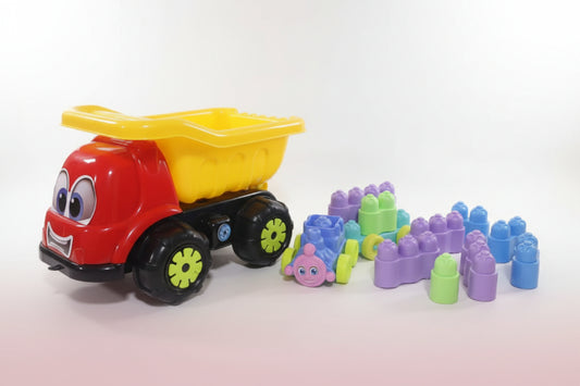 Colorful toy dump truck with building blocks on a wooden surface