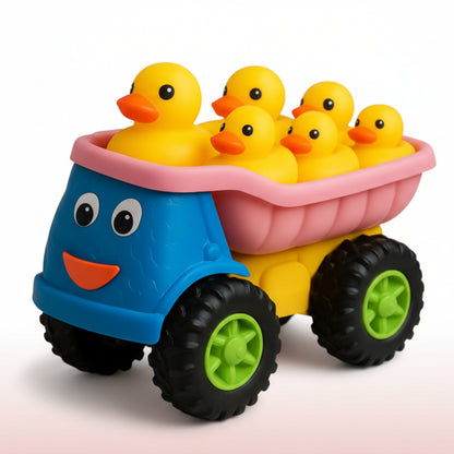 Toy truck with a blue body and pink bed carrying yellow rubber ducks on a colorful play mat.