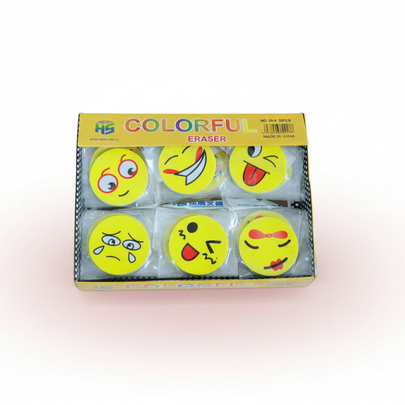 Box of colorful erasers with emoji designs on a wooden surface