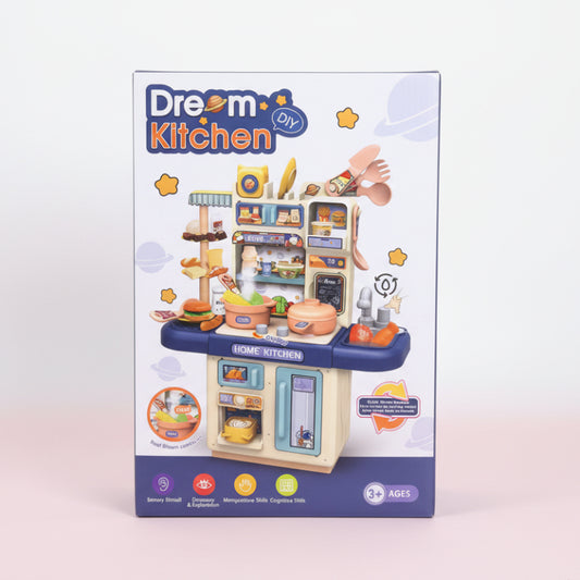 Box of a toy kitchen set with 'Dream Kitchen' branding on a wooden surface.