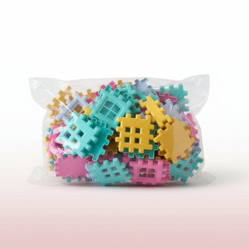 Colorful plastic building blocks in a clear plastic bag on a wooden surface.