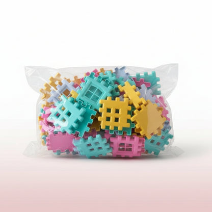 Colorful plastic building blocks in a clear plastic bag on a wooden surface.