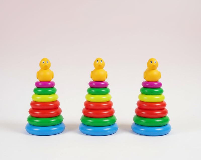 Three colorful stacking toys with duck figures on top, each in a clear plastic bag.