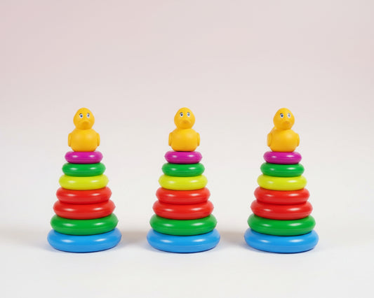 Three colorful stacking toys with duck figures on top, each in a clear plastic bag.