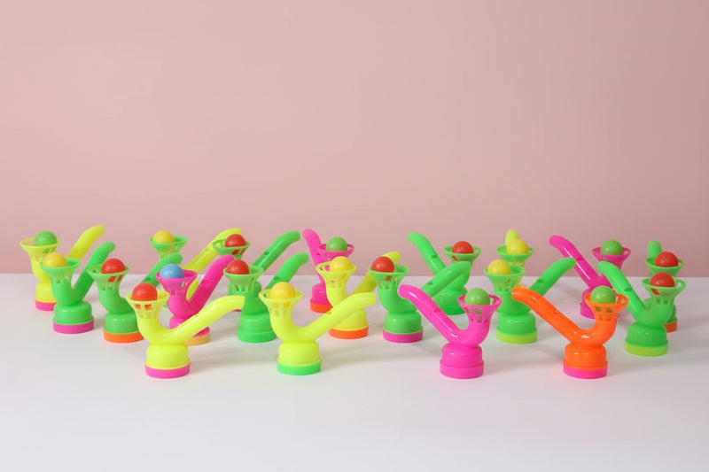 Colorful plastic nozzles arranged on a wooden surface with a plain background