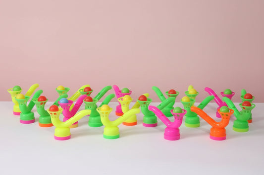 Colorful plastic nozzles arranged on a wooden surface with a plain background