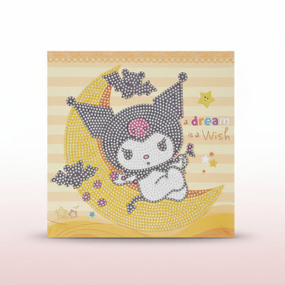 Card with a cartoon character on a moon, text 'A dream is a wish', on a wooden surface.