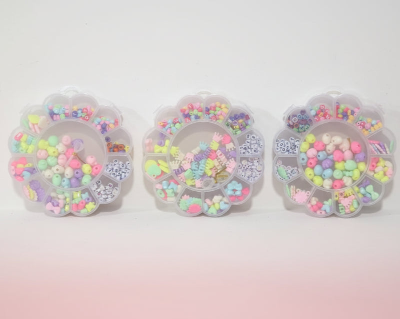Three clear containers filled with colorful beads on a wooden surface.