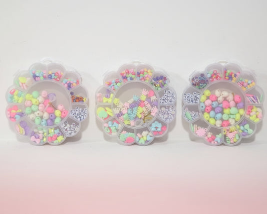 Three clear containers filled with colorful beads on a wooden surface.