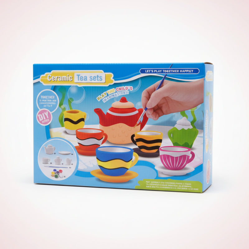 Box of ceramic tea sets with colorful illustrations on a wooden surface.