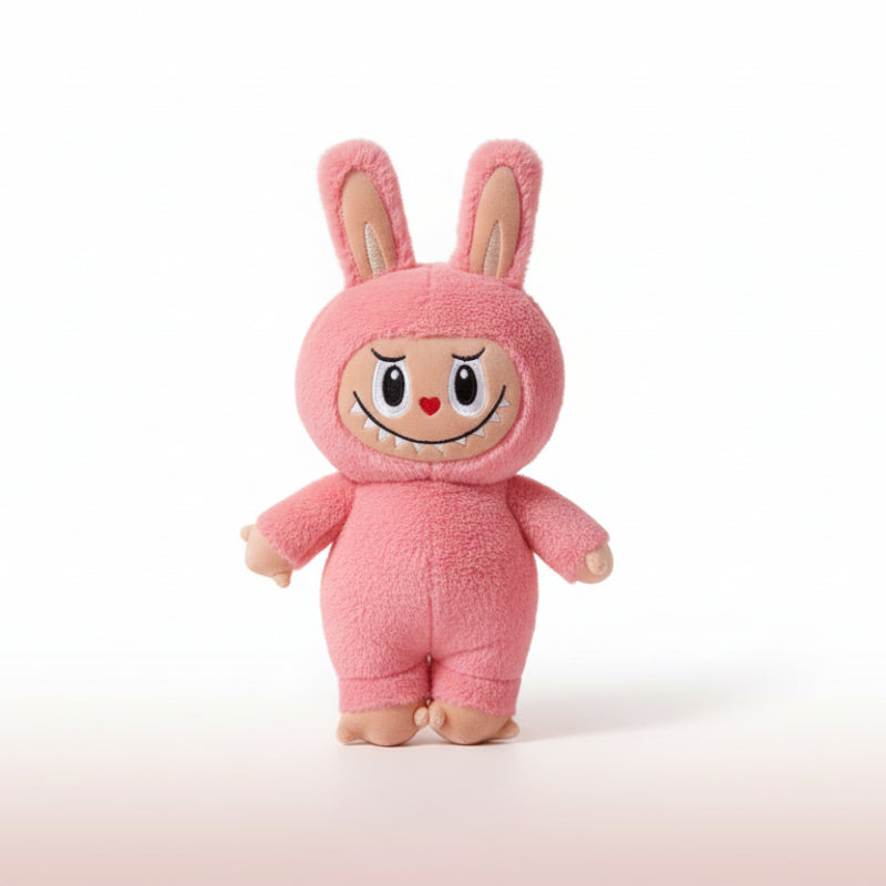 Pink plush toy with a cartoonish face on a wooden surface and white background