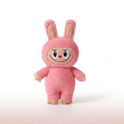 Pink plush toy with a cartoonish face on a wooden surface and white background