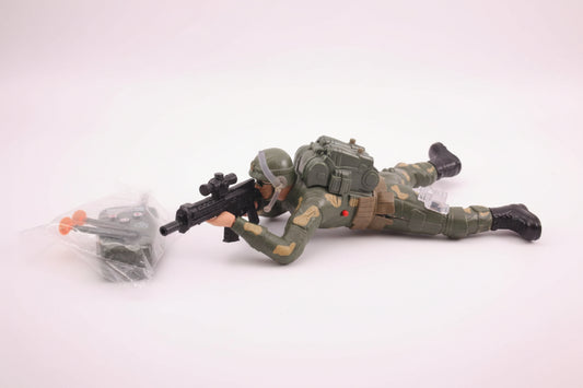 Toy soldier with weapon on a wooden surface next to a clear plastic bag