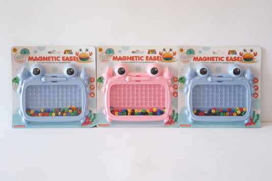 Three magnetic easels in packaging on a wooden surface with a beige wall background.