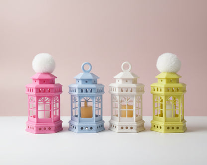 Four colorful lanterns with clear plastic covers on a wooden surface.
