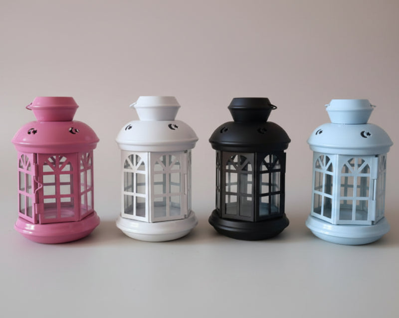 Four colorful lanterns on a wooden surface with a plain background
