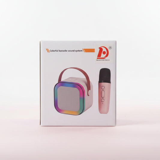 Box of a colorful karaoke sound system with a microphone on a wooden surface.