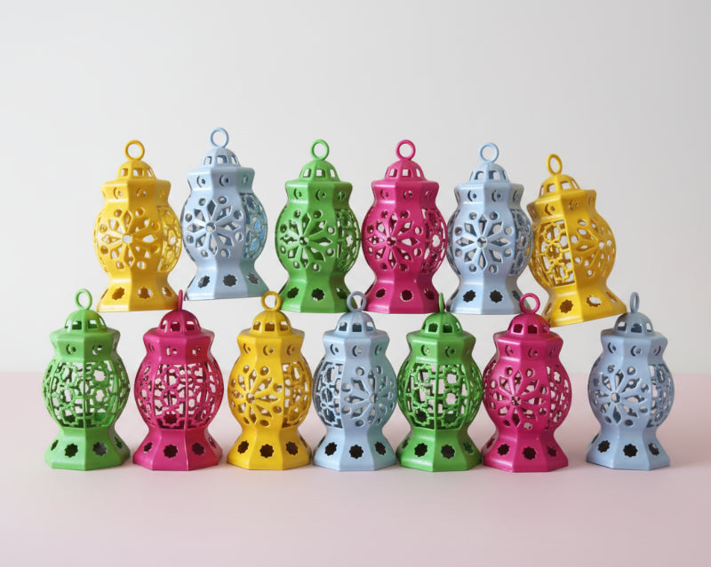 Colorful decorative lanterns arranged on a wooden surface with a pink wall background.