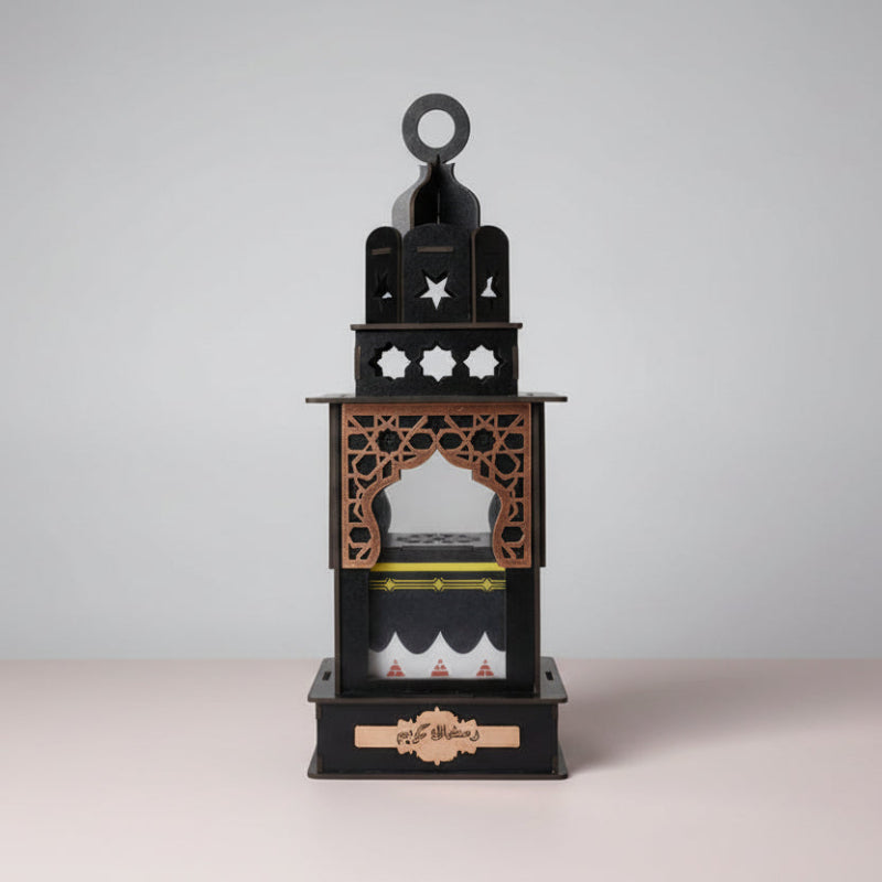 Decorative black lantern with intricate designs on a wooden surface