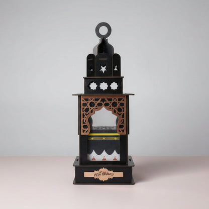 Decorative black lantern with intricate designs on a wooden surface