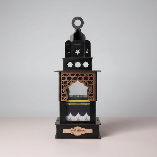 Decorative black lantern with intricate designs on a wooden surface