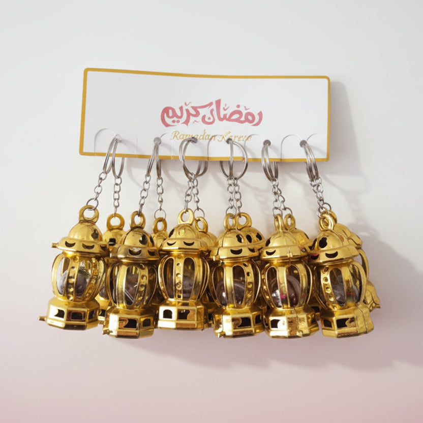 Gold lantern-shaped keychains on a display card with colorful designs.