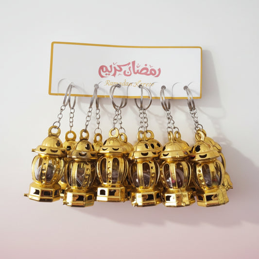 Gold lantern-shaped keychains on a display card with colorful designs.