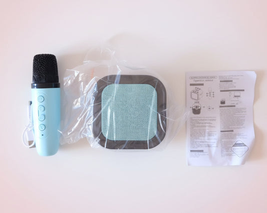 Microphone, plastic bag with filter, and paper manual on a wooden surface