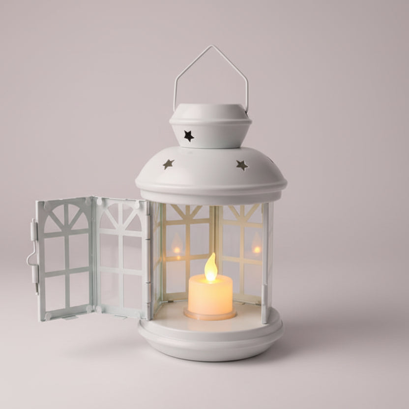 White lantern with a lit candle inside on a wooden surface