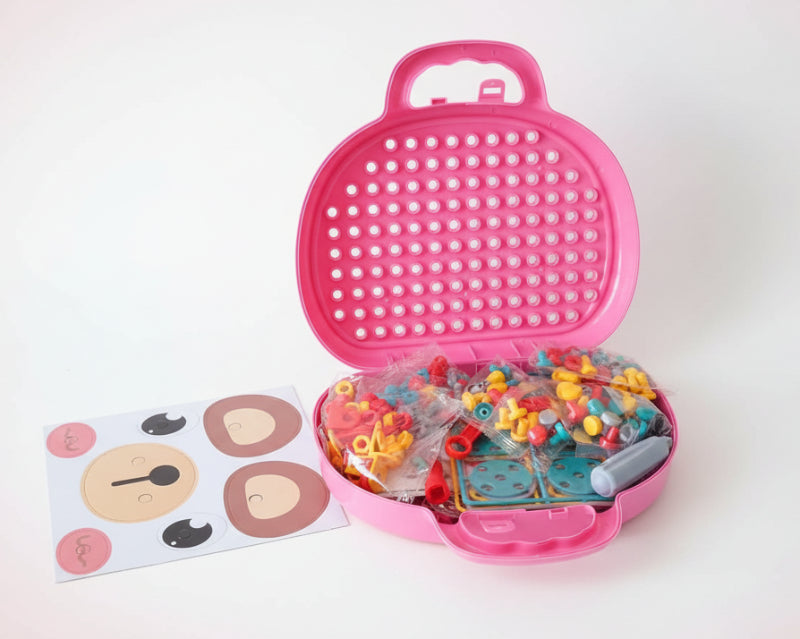 Toy building set in an open suitcase with colorful pieces and a sheet of stickers on a wooden surface.