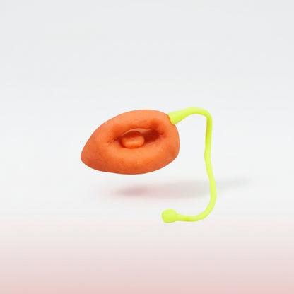 Orange object with a green string on a wooden surface