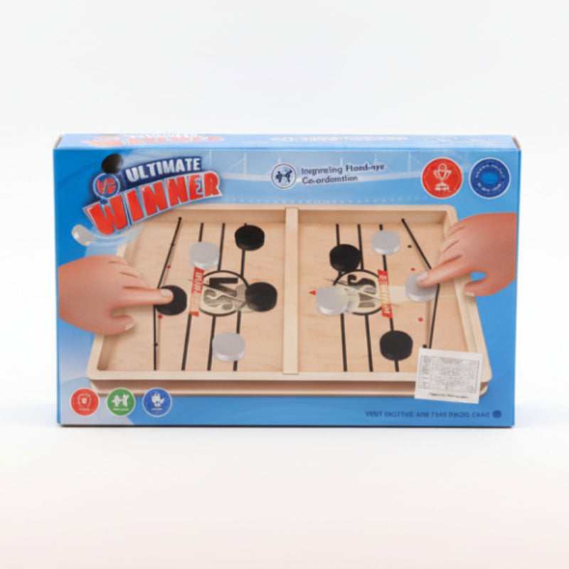 Box of 'Ultimate Winner' hand-eye coordination game on a wooden surface with a beige wall background.