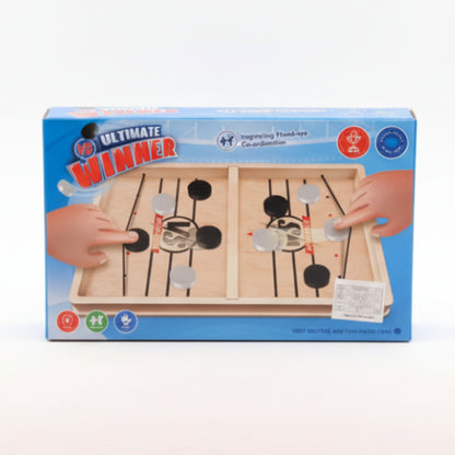 Box of 'Ultimate Winner' hand-eye coordination game on a wooden surface with a beige wall background.