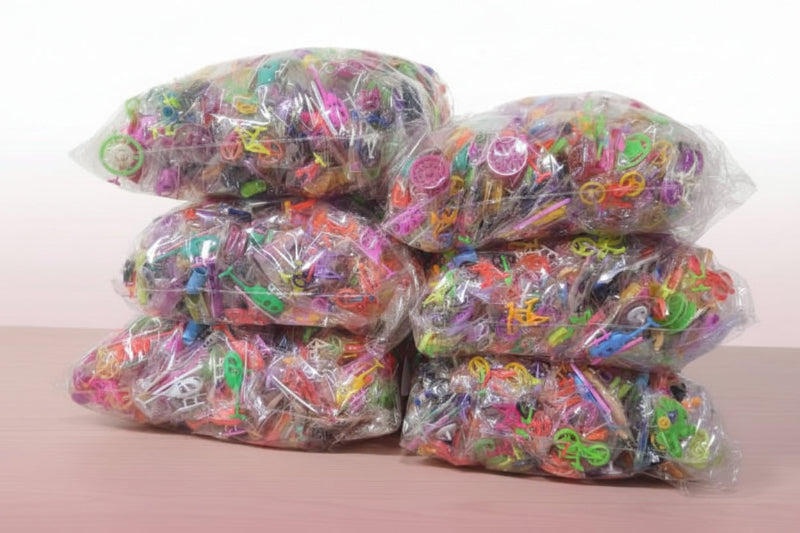Multiple bags of colorful rubber bands on a wooden surface with a white background