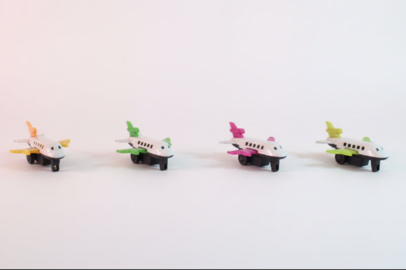 Four toy airplanes on a wooden surface with a plain background