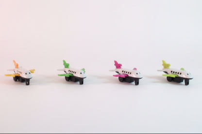 Four toy airplanes on a wooden surface with a plain background