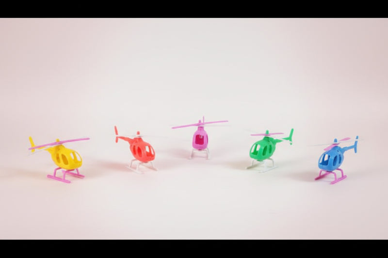 Five colorful toy helicopters on a wooden surface with a plain background