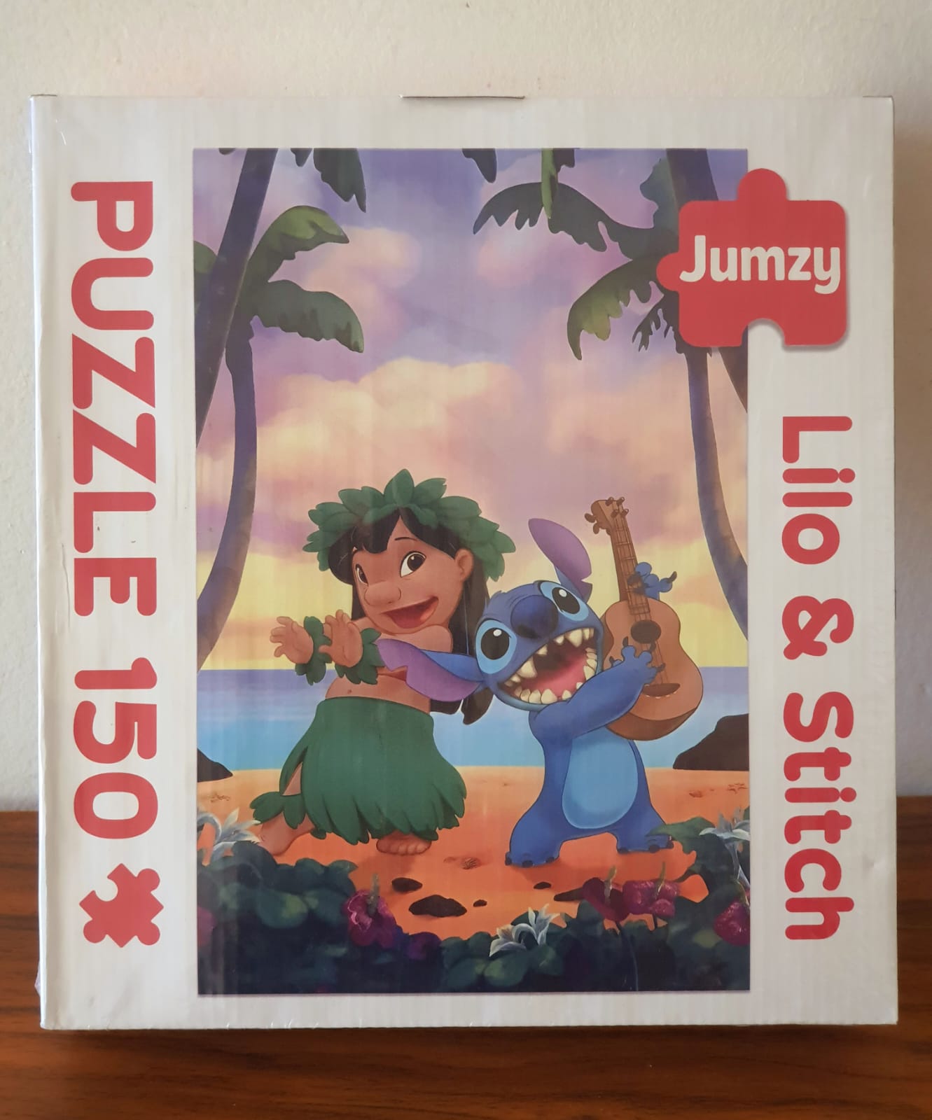 Jigsaw puzzle box featuring Lilo and Stitch with 'Jumzy' branding on a wooden surface.