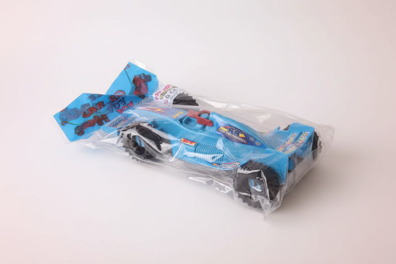 Toy car in packaging on a wooden surface
