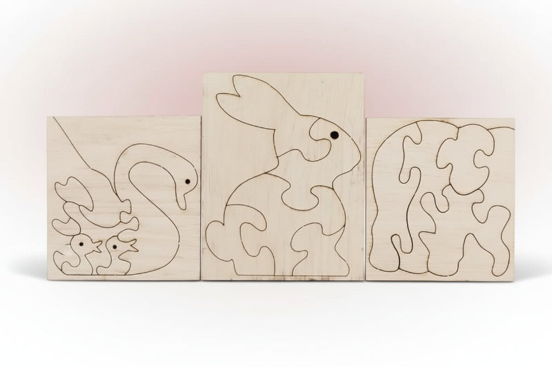Three wooden puzzle boards with animal outlines on a reflective surface.